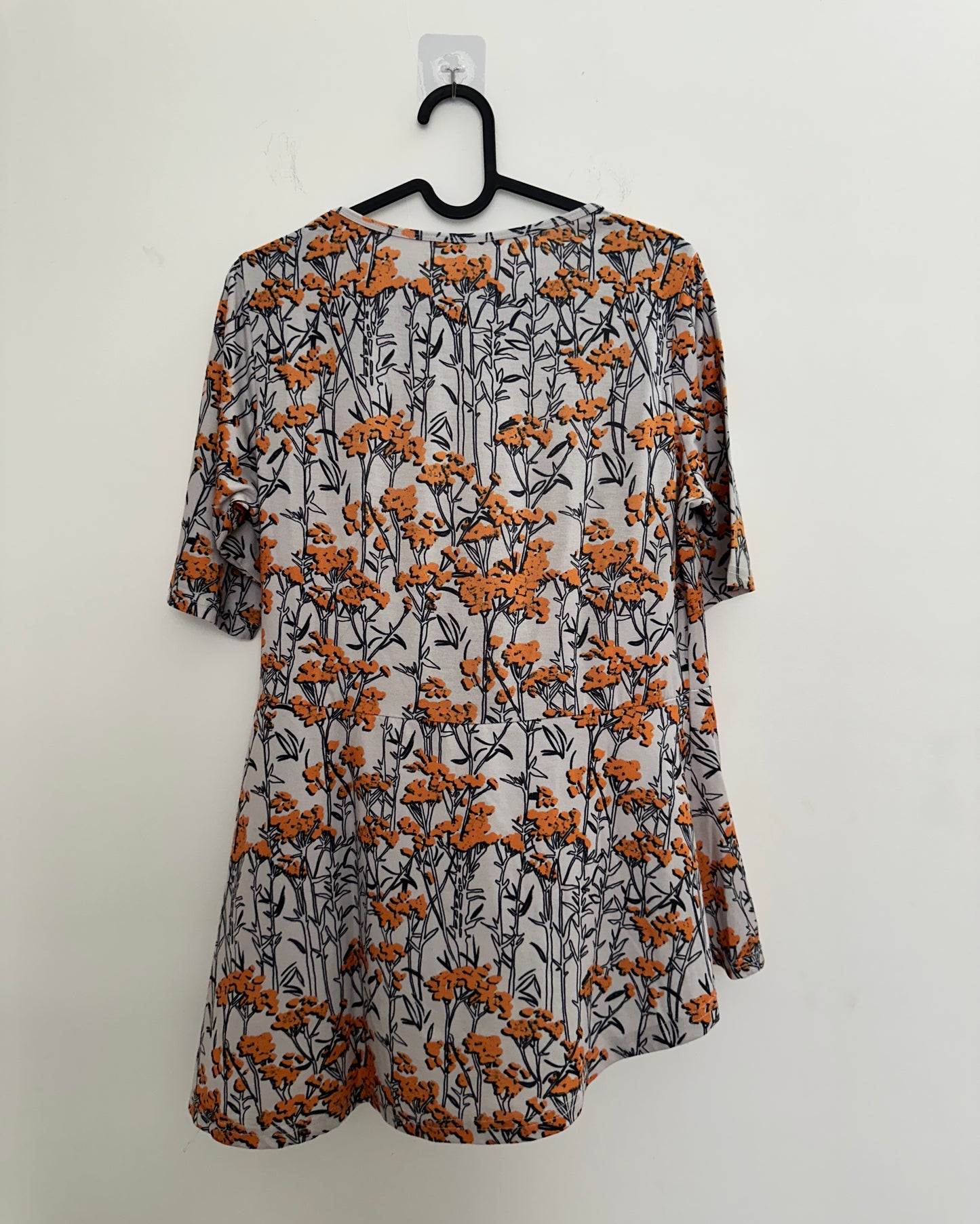 White and orange floral top with asymetric pleats