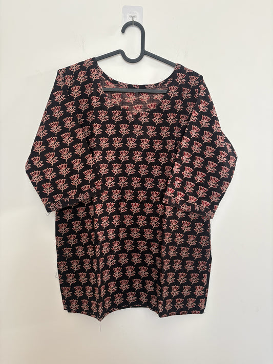 The Circle black cotton kurti featuring a pink floral block print, round notch neckline, and three-quarter sleeves.