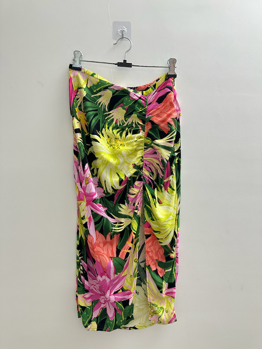 The Circle floral midi skirt featuring a black base with vibrant yellow, pink, and coral botanical print and side ruching