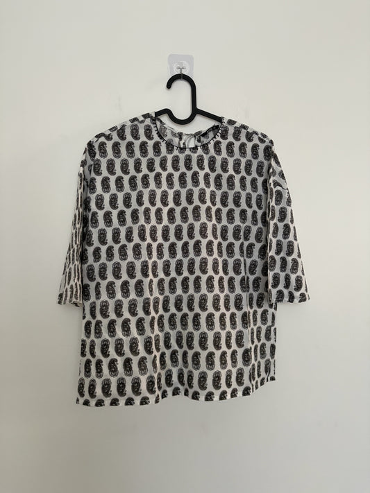 The Circle monochrome paisley print top with three-quarter sleeves, round neck, and relaxed boxy fit on a hanger