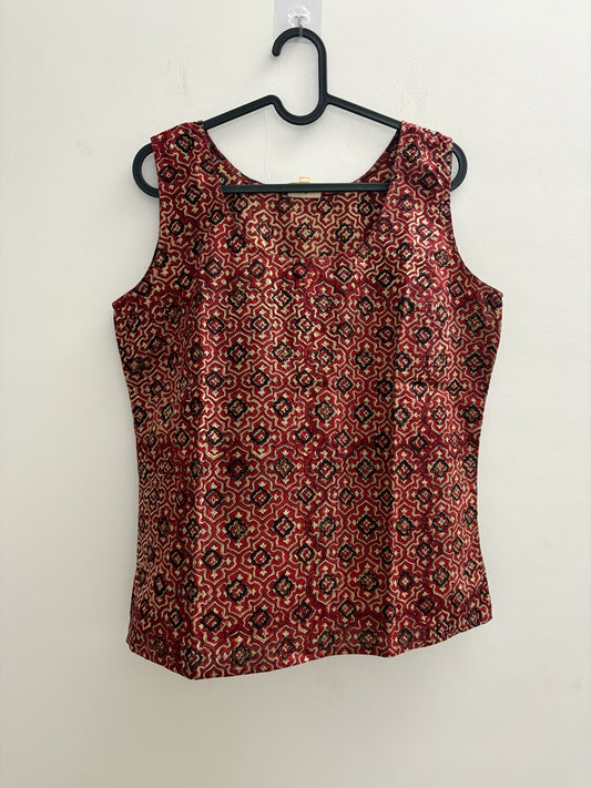 The Circle sleeveless cotton top in deep red with a black and cream geometric print and a classic round neckline.