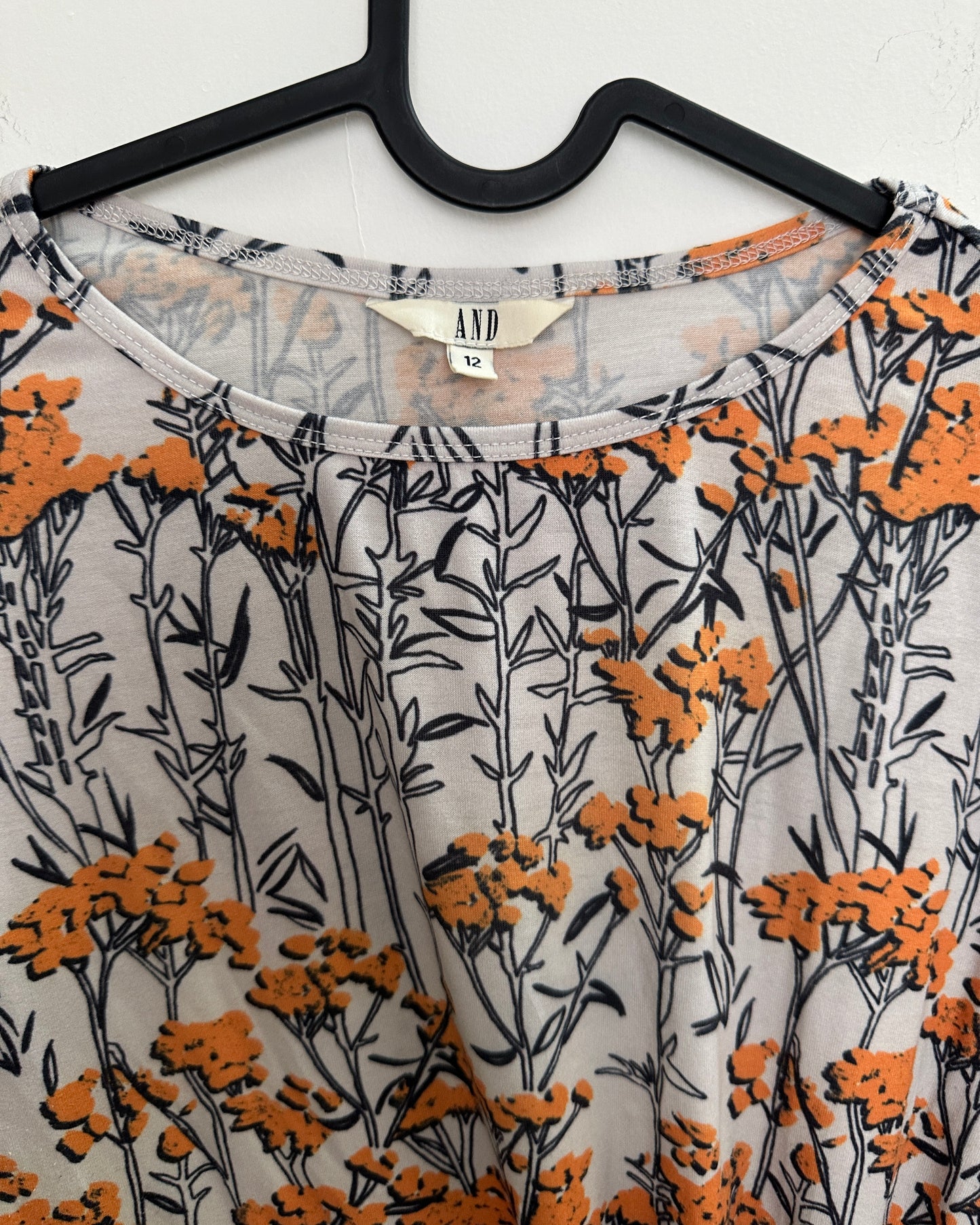White and orange floral top with asymetric pleats