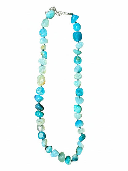 The Circle handcrafted necklace featuring polished blue agate stones in varying shades with a silver-toned clasp.