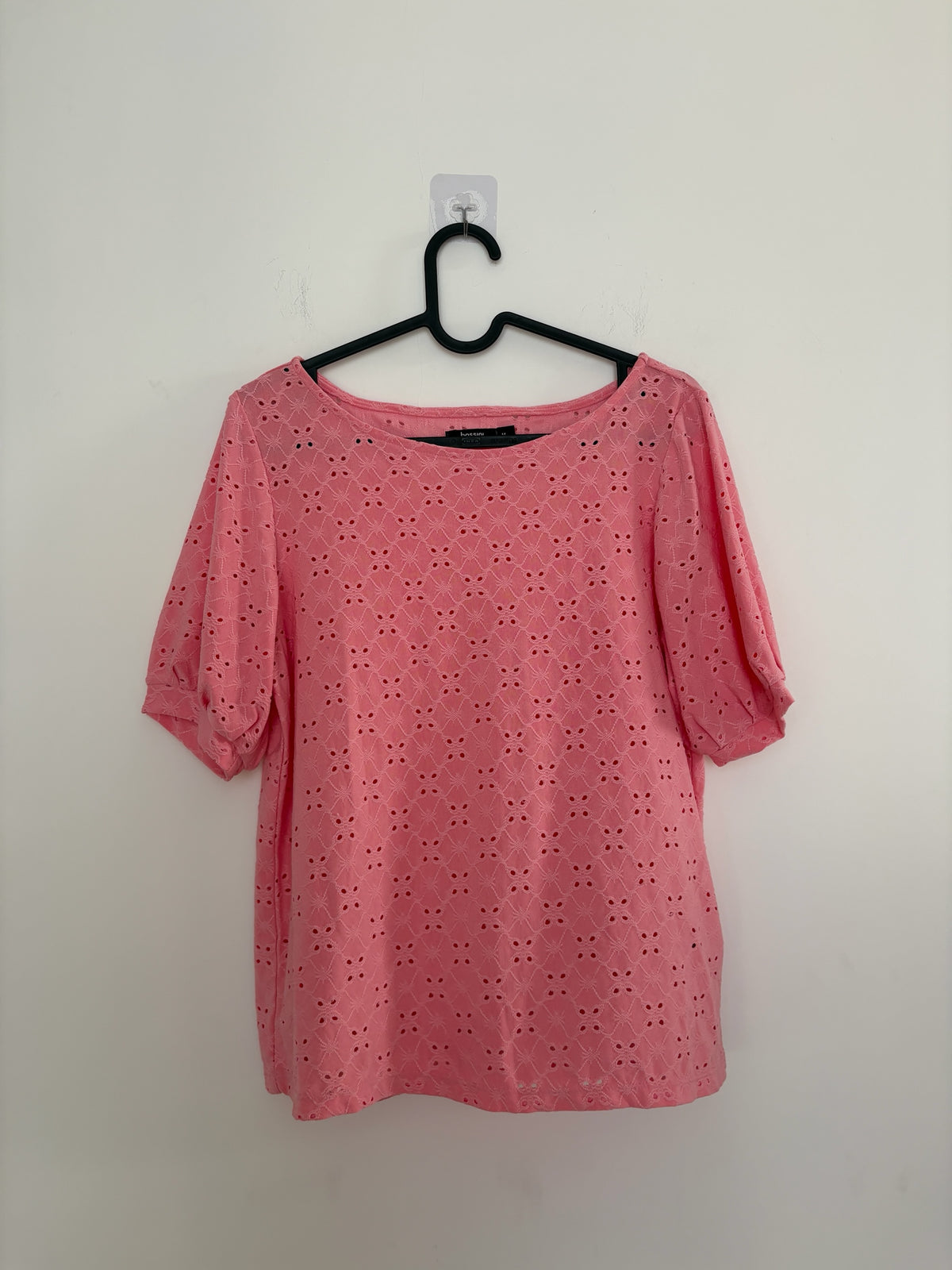 The Circle bossini pink eyelet embroidered casual top with round neckline and short puff sleeves on a hanger