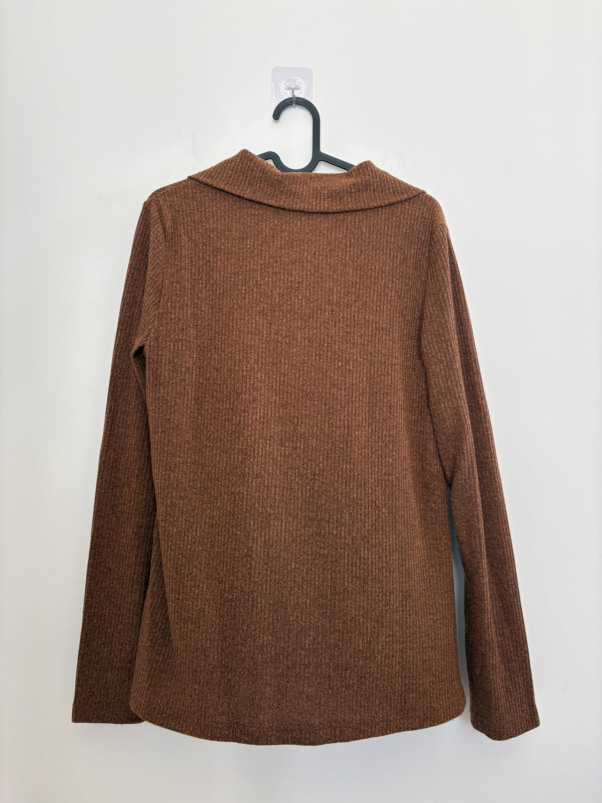 The Circle brown ribbed knit long-sleeve shirt with a polo collar, shown from the back on a hanger.
