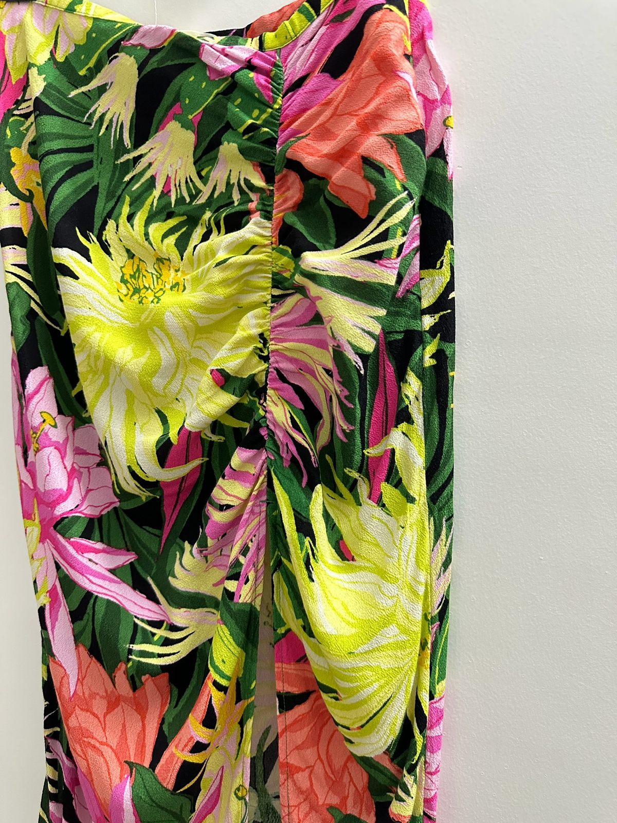 The Circle floral print midi skirt in black with vibrant yellow, pink, and coral botanical motifs and side ruching.