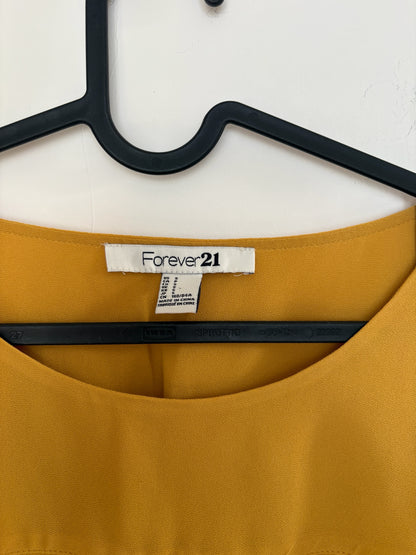 The Circle Forever 21 mustard yellow casual blouse with a round neckline and size small label on a black hanger.