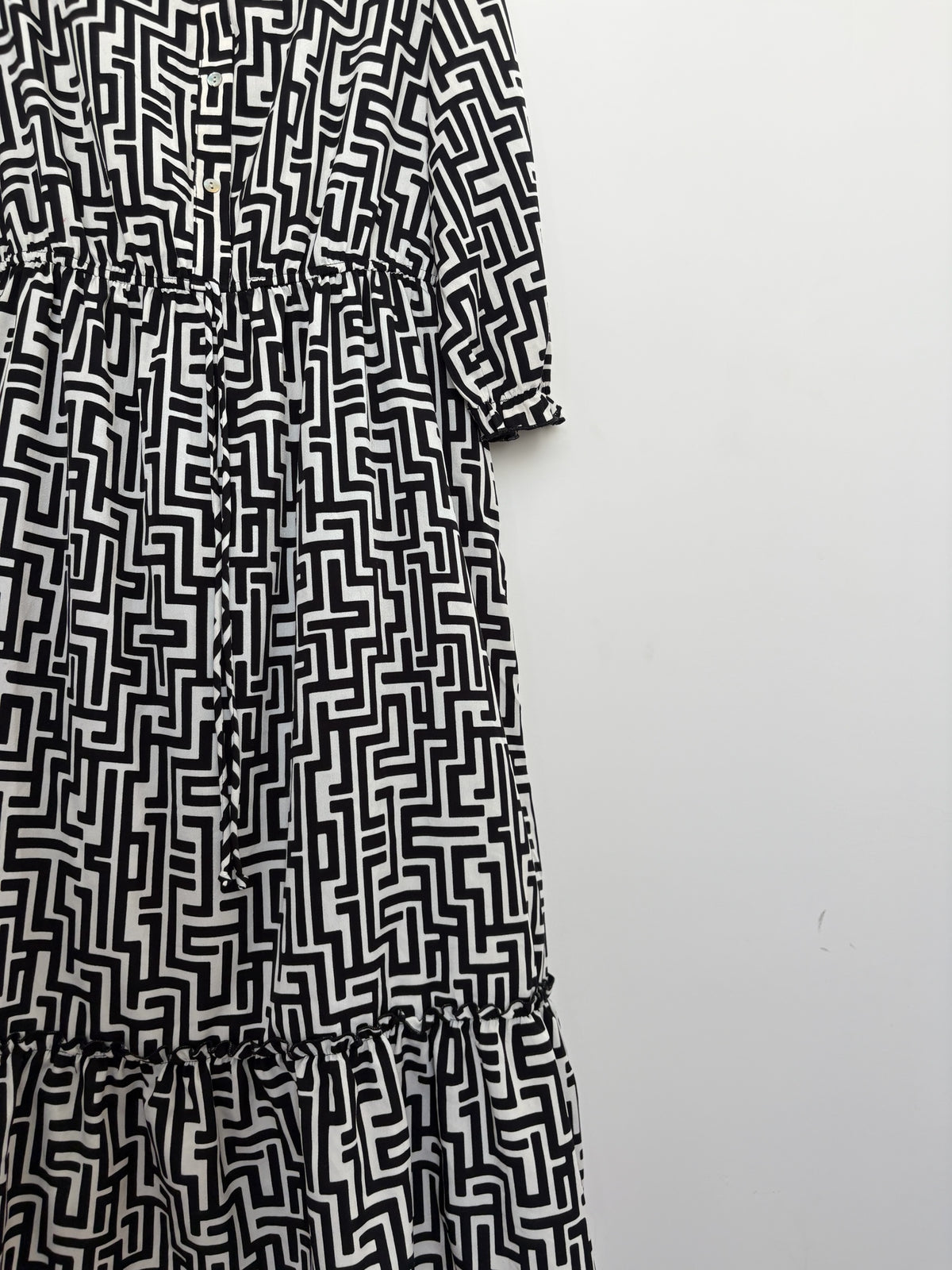 The Circle black and white geometric print midi dress with a button-down front, elasticated waist, and tiered hem.