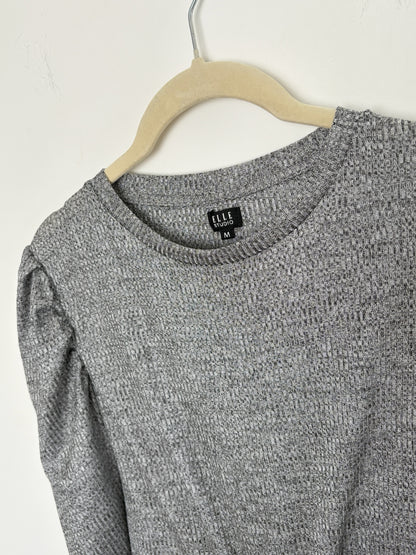 The Circle grey textured knit pullover top by ELLE STUDIO featuring a crew neckline and puff sleeves on a hanger.