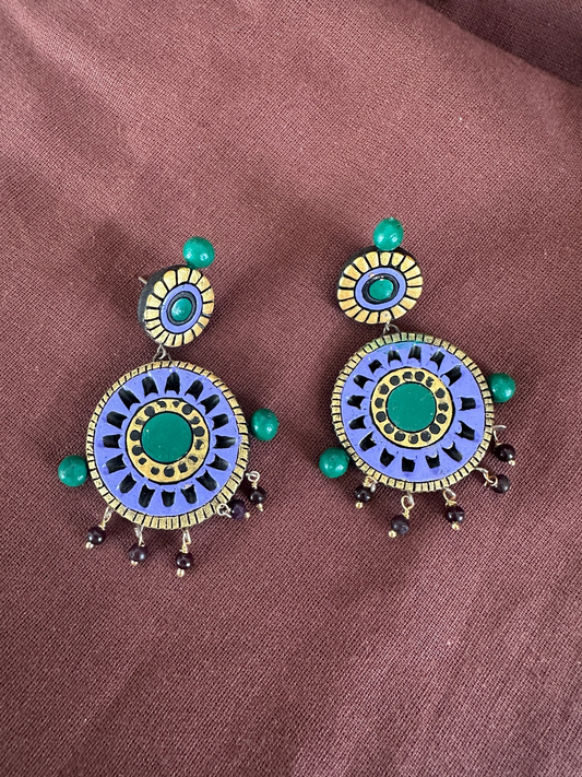 The Circle handcrafted terracotta statement earrings featuring hand-painted purple, green, and gold circular designs.