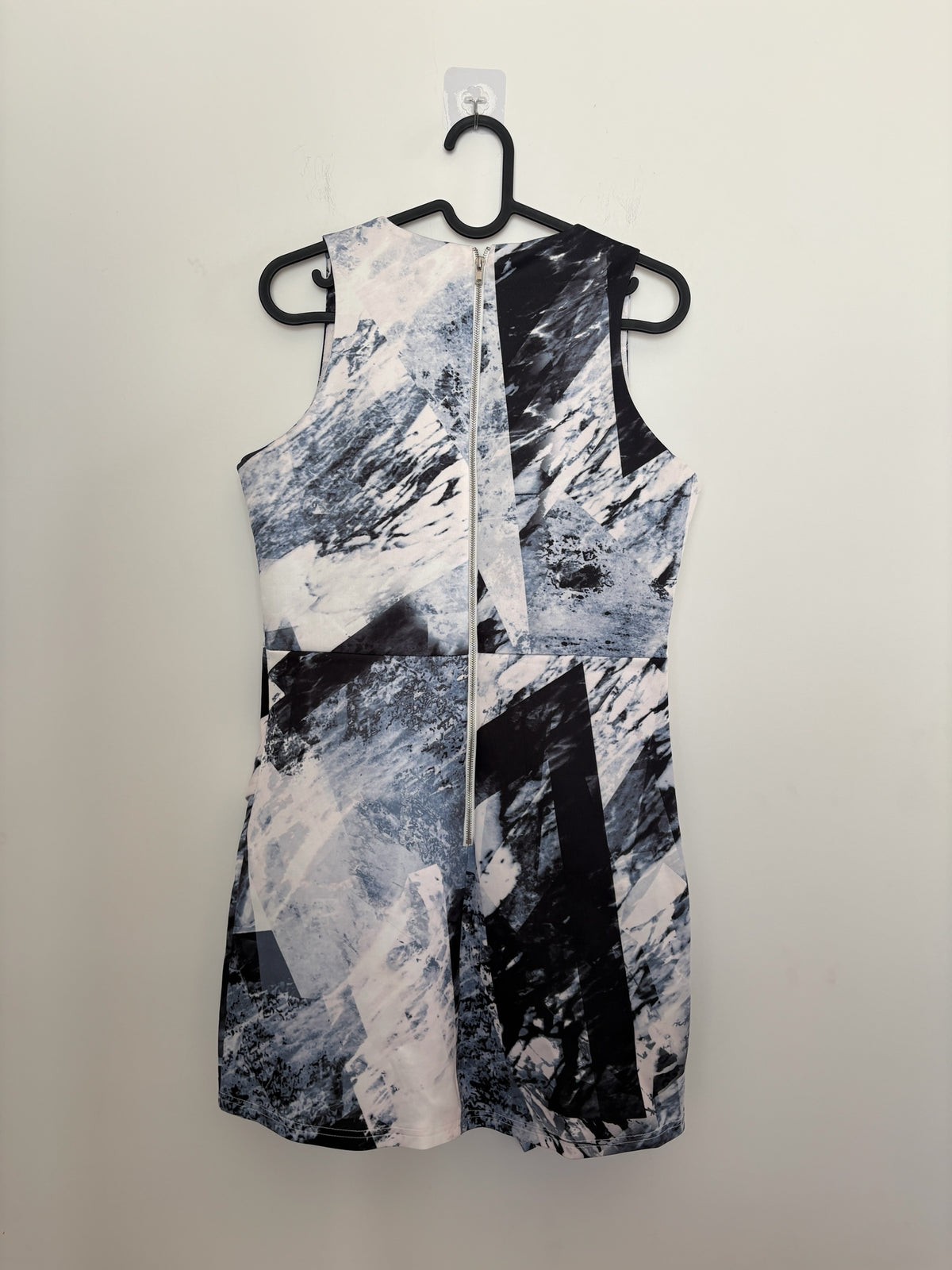 The Circle sleeveless mini dress featuring a monochrome abstract geometric print and a full-length back zipper closure.