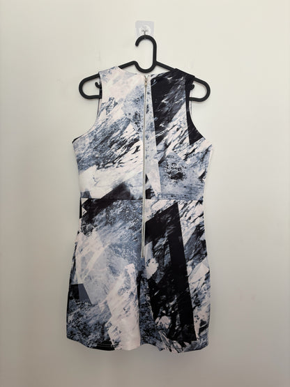 The Circle sleeveless mini dress featuring a monochrome abstract geometric print and a full-length back zipper closure.