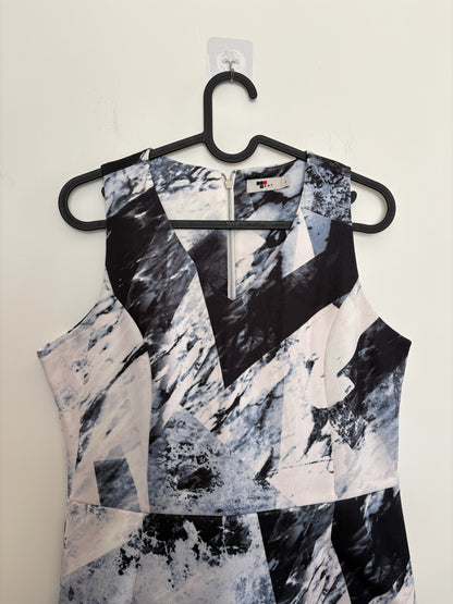 The Circle sleeveless mini dress featuring a monochrome abstract geometric print with a V-neckline and back zipper.