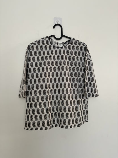 The Circle monochrome paisley print top with three-quarter sleeves, round neck, and relaxed boxy fit on a hanger