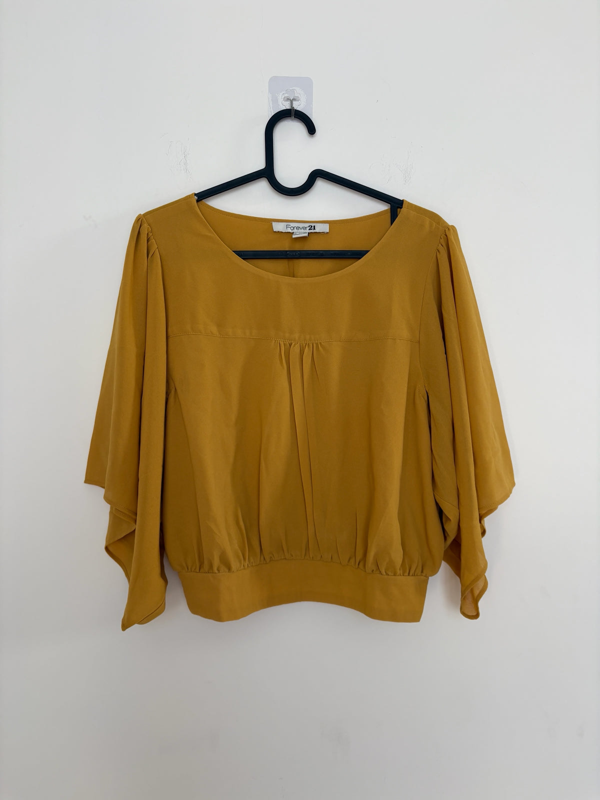 The Circle Forever 21 mustard yellow blouse with flutter sleeves, round neckline, and gathered front detail.