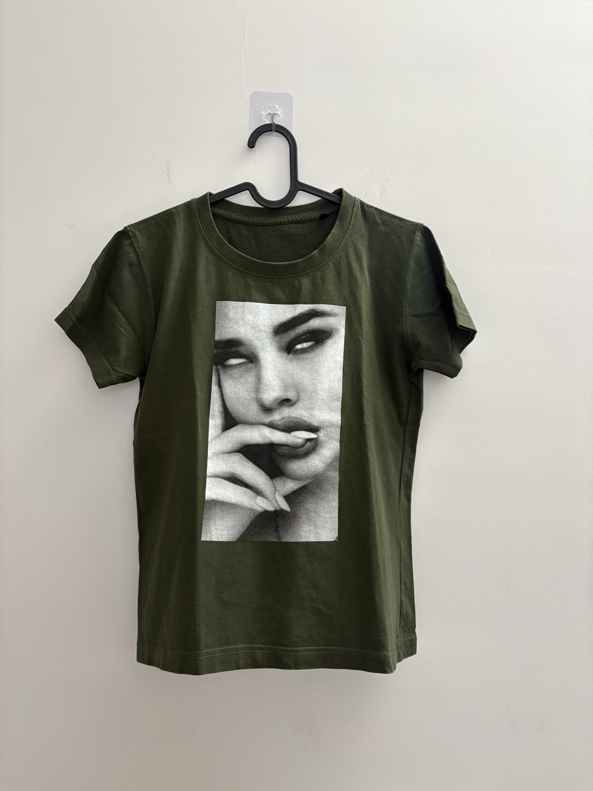 The Circle olive green crew neck t-shirt featuring a black and white photographic print of a woman's face.