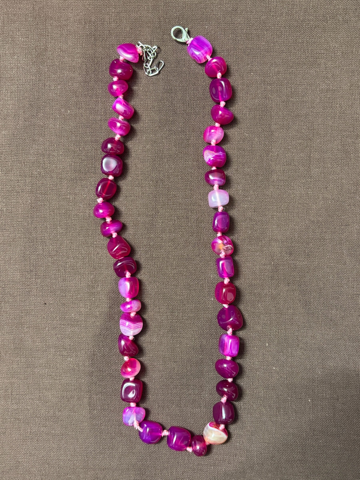 The Circle handcrafted statement necklace featuring vibrant pink and magenta polished agate gemstone beads.