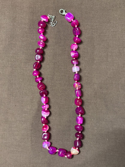 The Circle handcrafted statement necklace featuring vibrant pink and magenta polished agate gemstone beads.