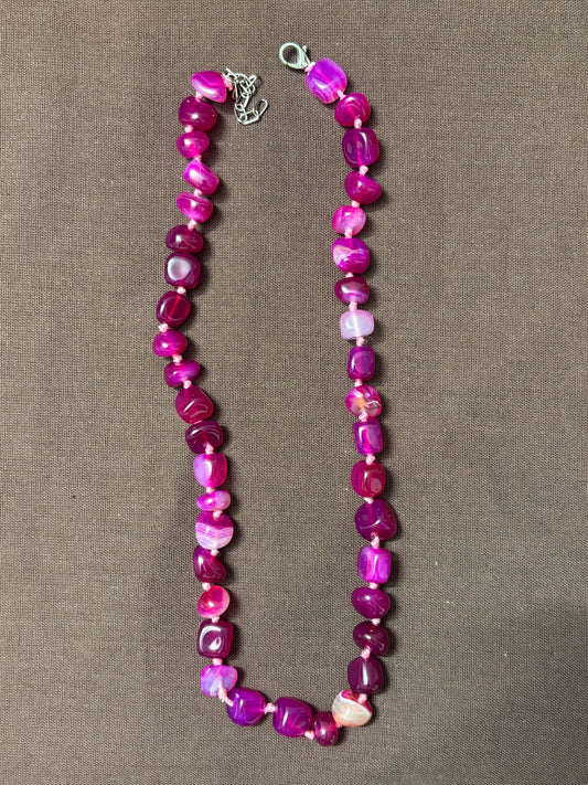 The Circle handcrafted statement necklace featuring vibrant pink and magenta polished agate gemstone beads.