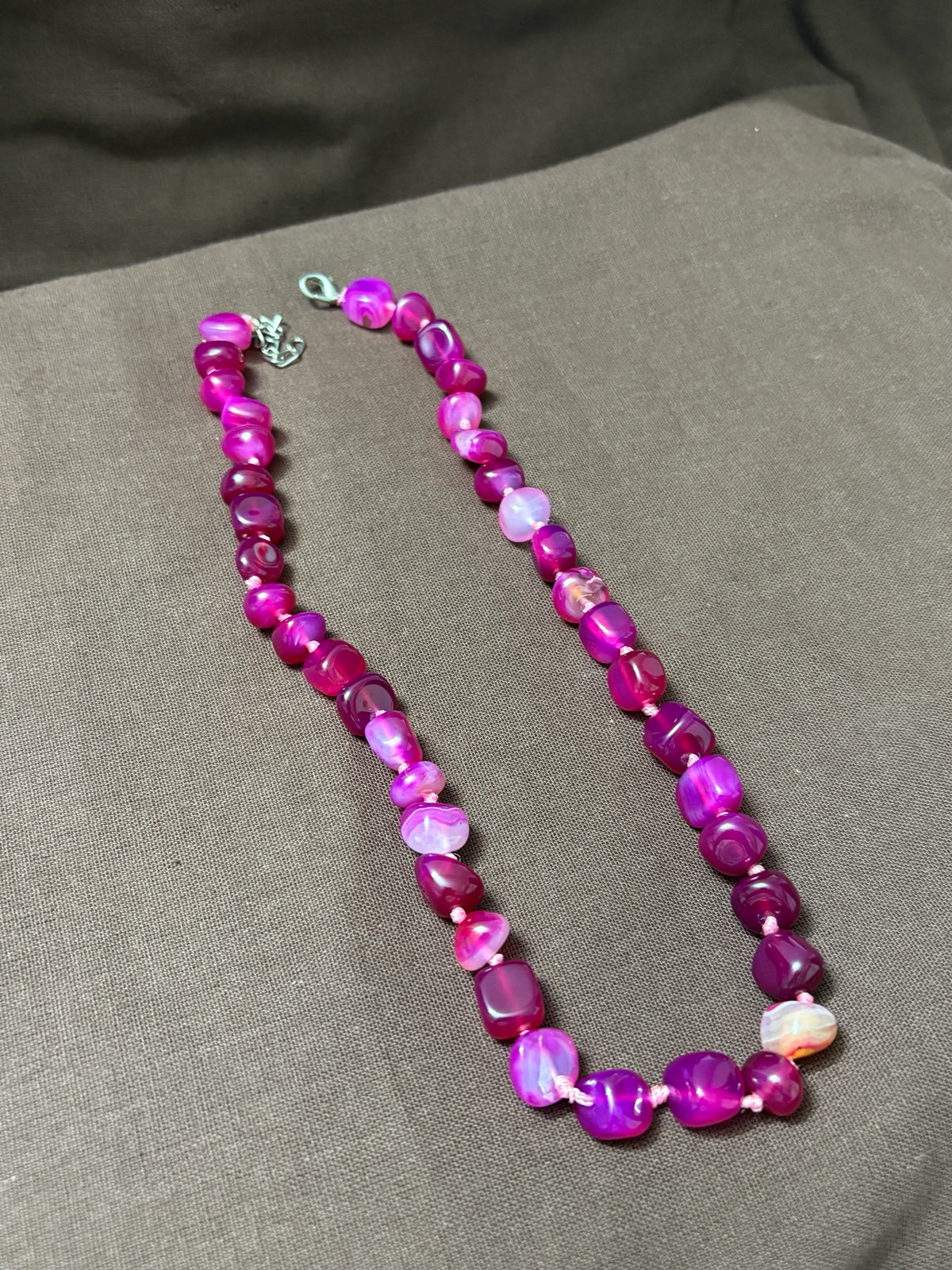 The Circle handcrafted statement necklace featuring vibrant pink and magenta polished agate gemstone beads.