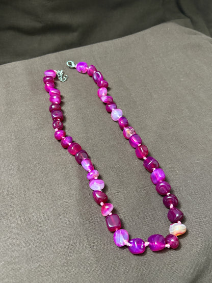 The Circle handcrafted statement necklace featuring vibrant pink and magenta polished agate gemstone beads.