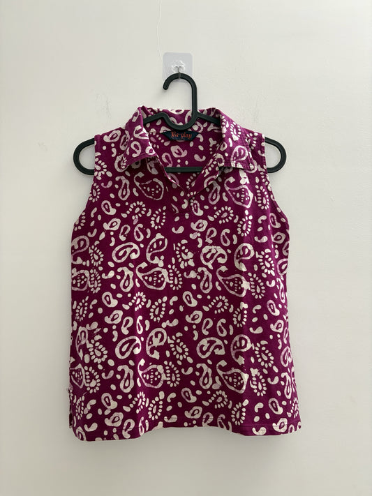 The Circle sleeveless polo top in deep purple with a white batik paisley print, featuring a structured collar.