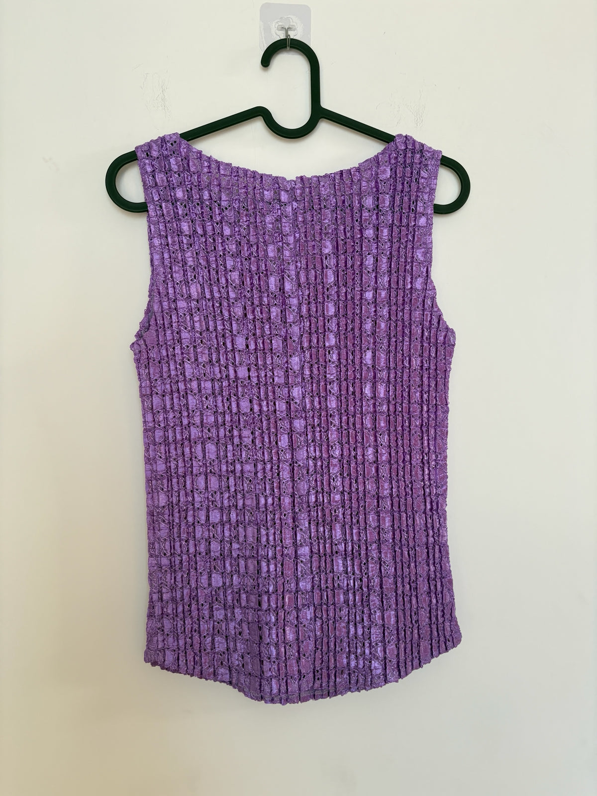 The Circle purple sleeveless top with a textured crinkle fabric finish and a classic V-neckline on a hanger.