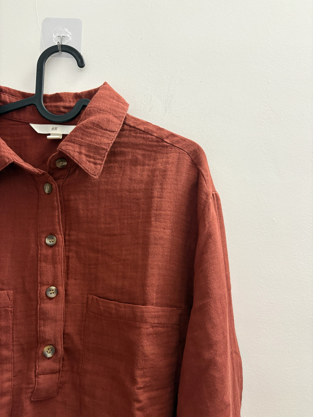 The Circle rust-coloured long sleeve button-down shirt with a textured finish, classic collar, and chest pocket.