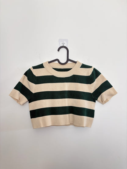 The Circle striped knit crop top in forest green and cream with a crew neckline and short sleeves on a hanger