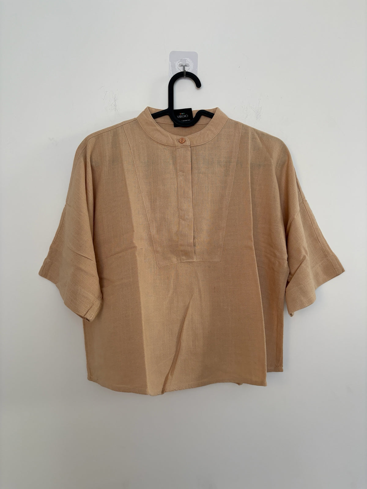 The Circle VIRGIO beige linen-blend boxy top with a mandarin collar and elbow-length sleeves on a hanger.